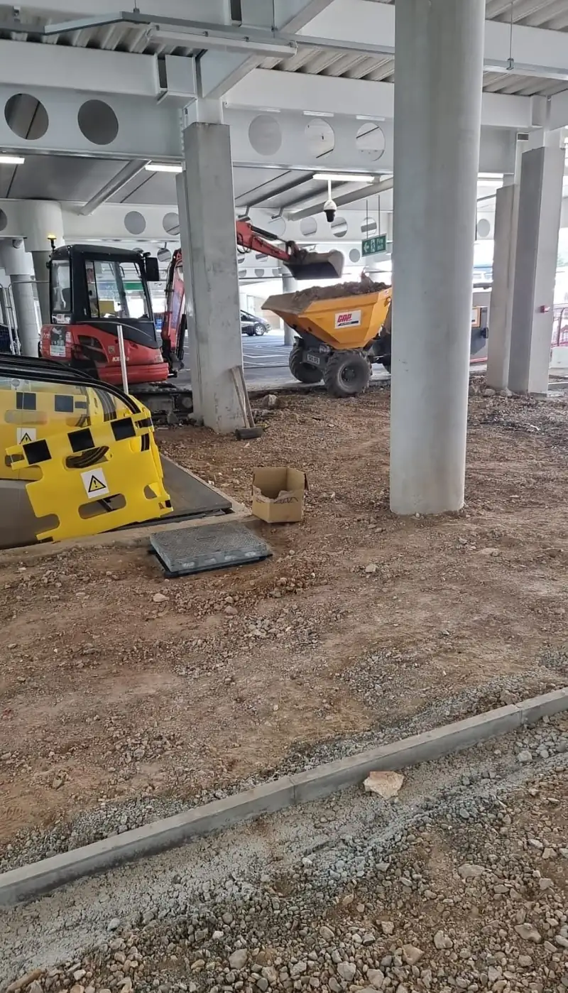 Mini excavator and dumper preparing the ground beneath a car park deck